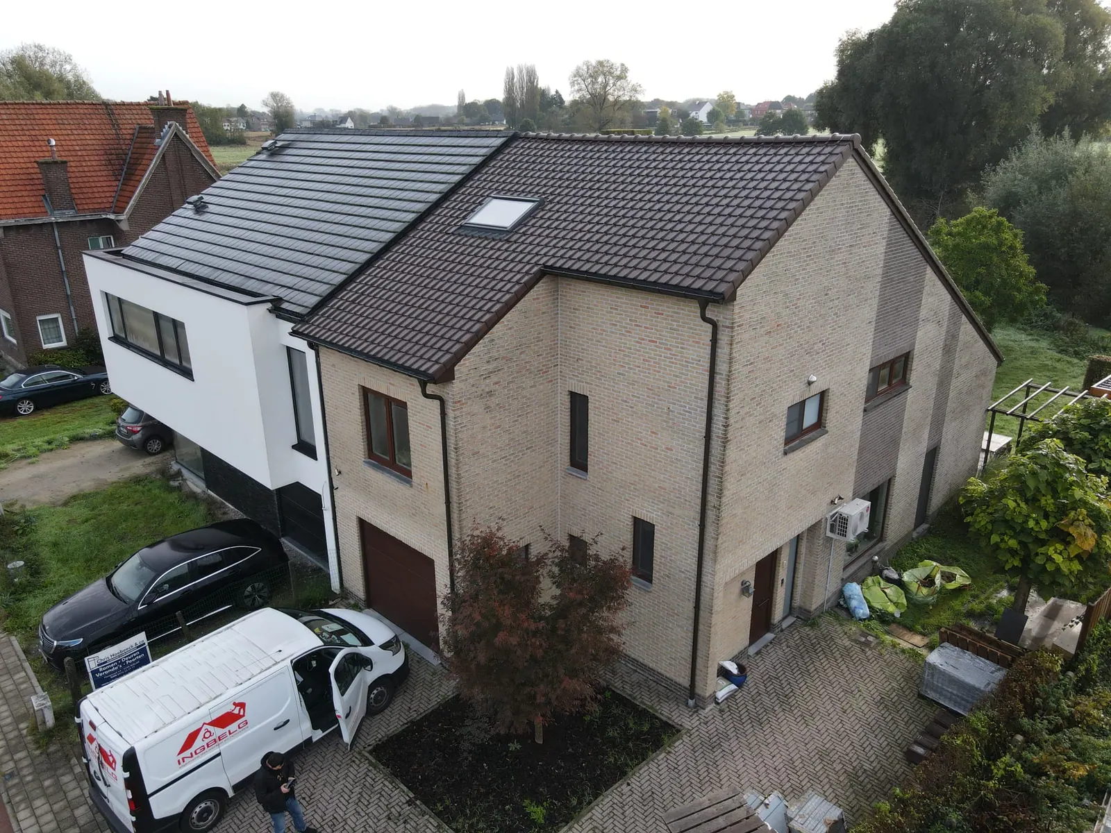 Woning met een nieuw bruin pannendak en dakvenster, met de bestelwagen van INGBELG voor de deur