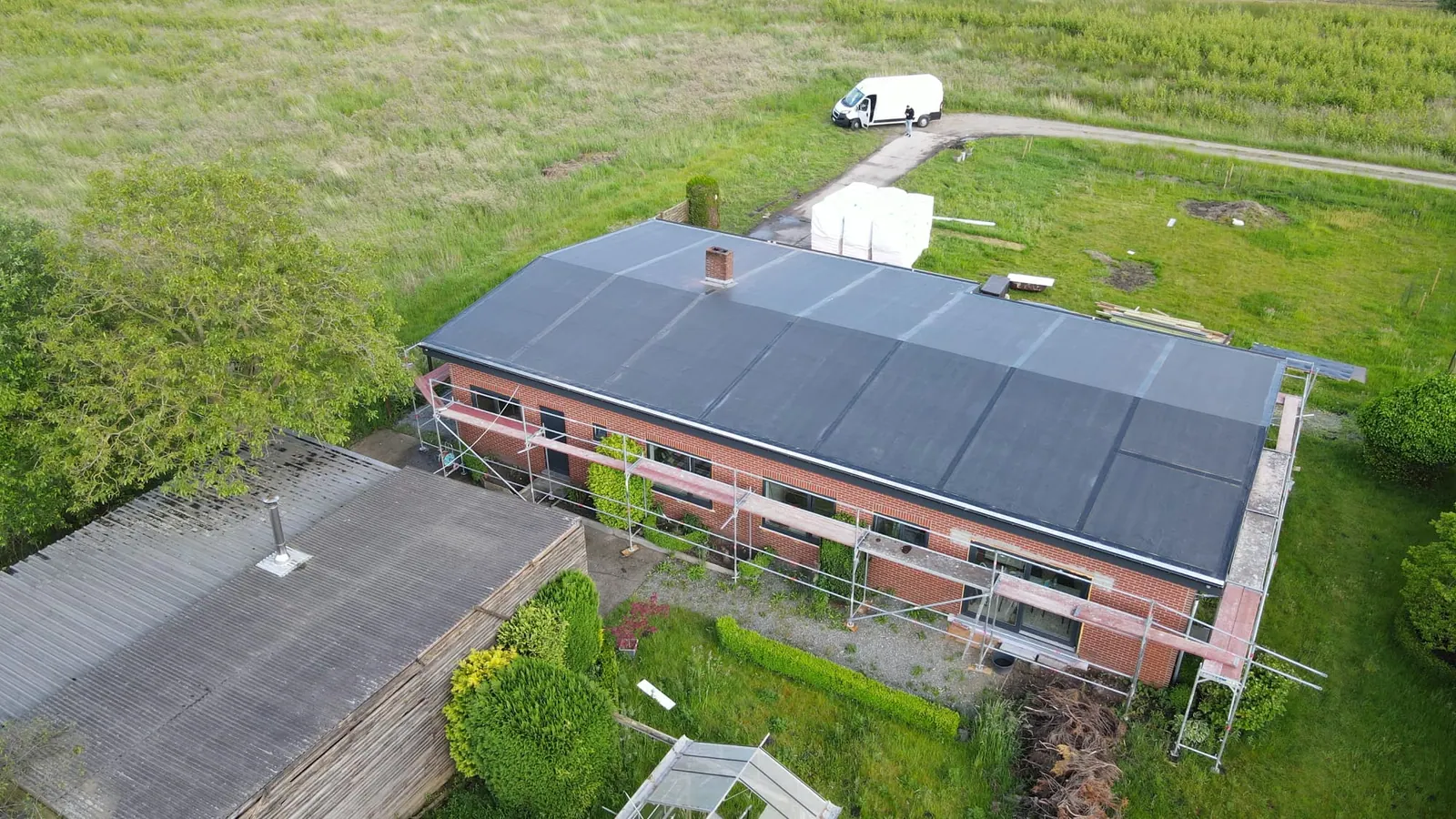 Langgerekte woning in de stellingen met een nieuwe donkere dakbedekking